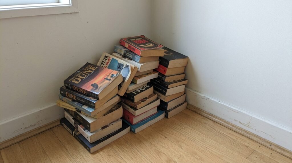 close up of reading nook with a throw blanket, pillow, and stack of books